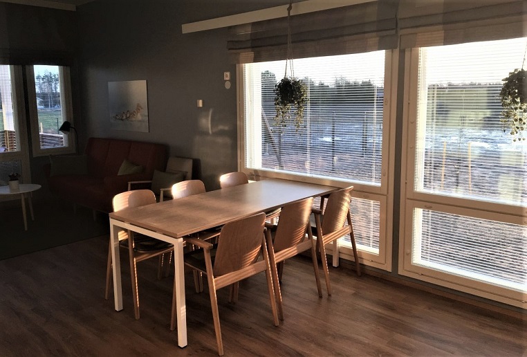 Onnikoti Tähtitaivaan ruokapöytä, jonka vieressä ovat isot ikkunat.