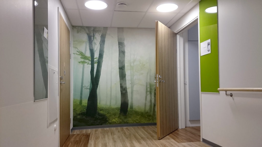 Onnikoti Alvarin käytävä, jonka päädyssä on metsäaiheinen seinämaalaus.