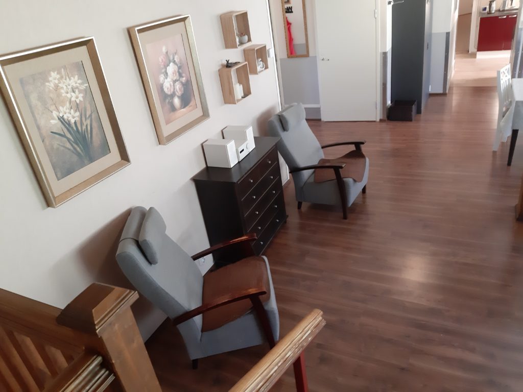 Onnikoti Kertun olohuone, jossa näkyy kaksi nojatuolia, lipasto ja kaksi taulua