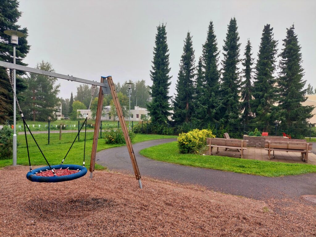 Onnikoti Toukolan piha, jossa keinu ja taustalla metsää.
