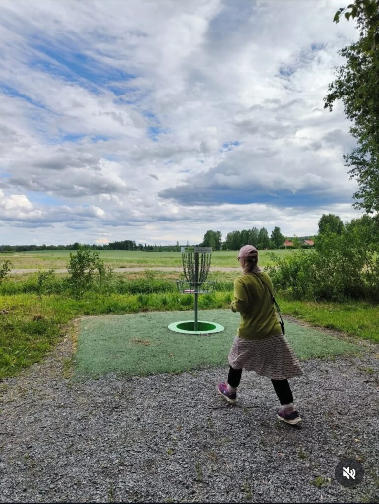 Ihminen ja frisbeegolf kori 