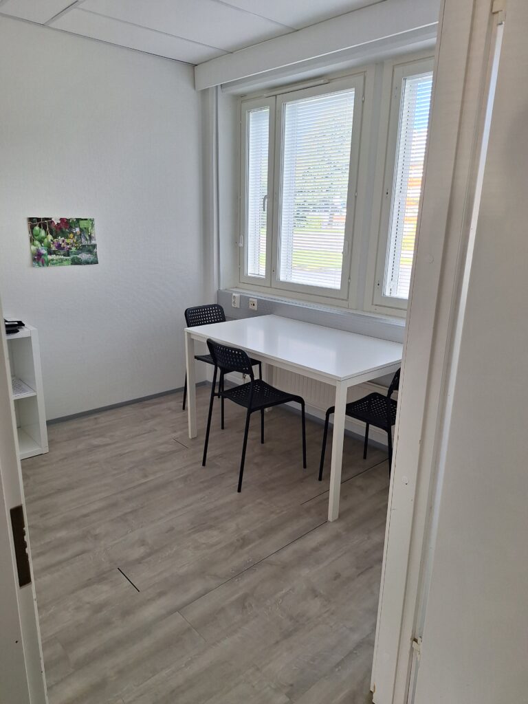 Huone, jossa pöytä ja tuolit.