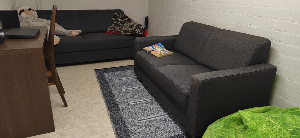 päivätoiminta Kristallin oleskelutila, jossa kaksi tummaa sohvaa.