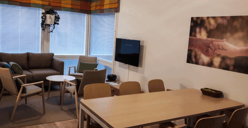 Onnikoti Kehrä, taulutelevisio, ruokailuryhmä, sohva sekä tuoleja.