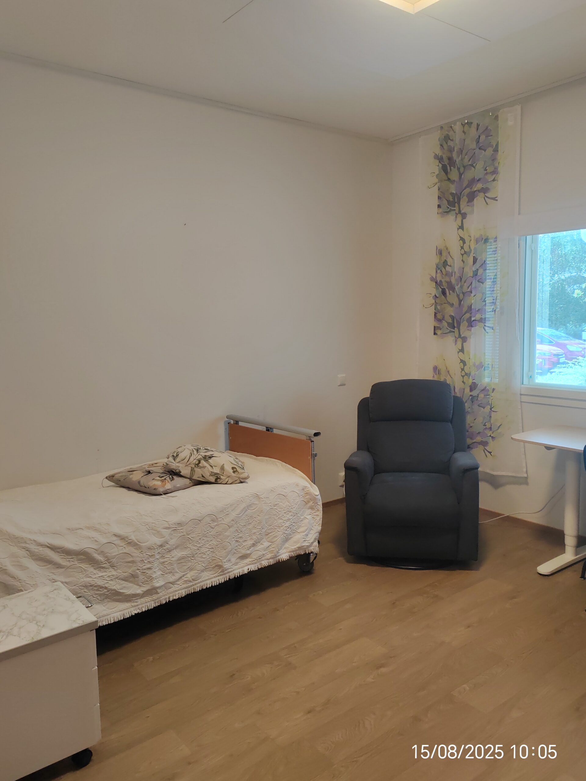 Huone, jossa sänky ja nojatuoli