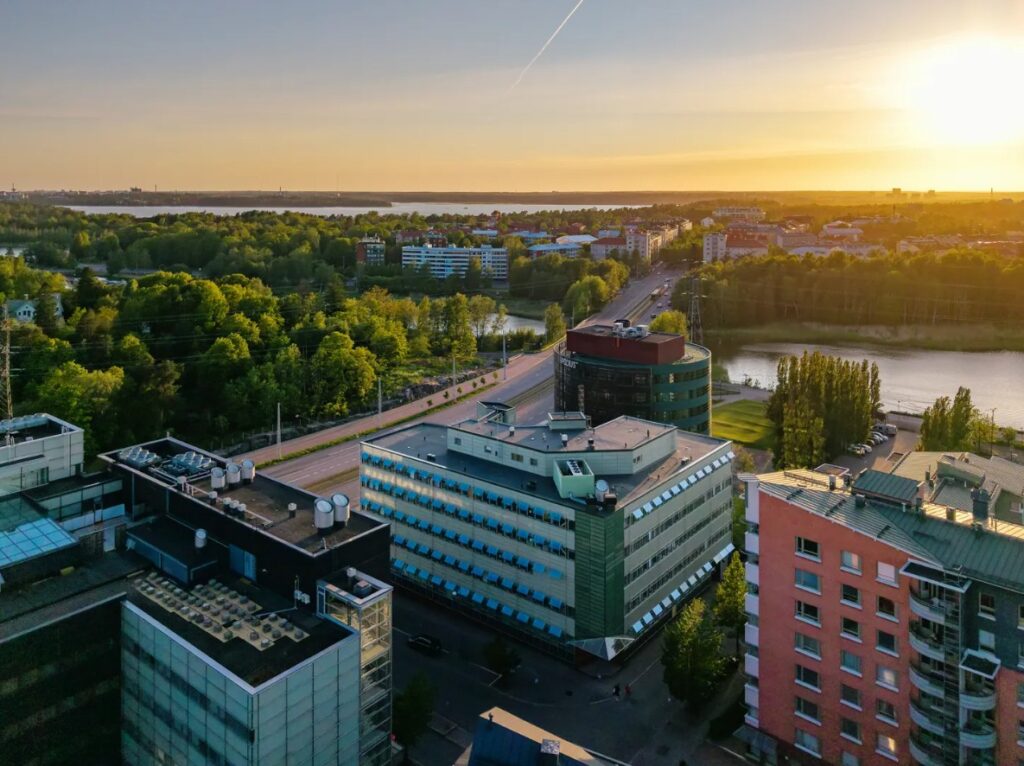 Ilmakuva Meilahdesta, merta, rakennuksia, aurinko