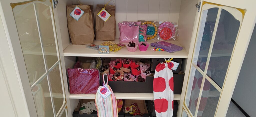 Onnikotien Kristallissa myytäviä tuotteita kaapissa