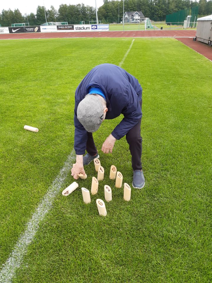 Onnikoti Tähtitaivaan asukas kerää mölkkypalikoita nurmikolta.